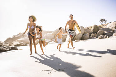 Glückliche Familie beim Laufen am Strand - SDAHF00458