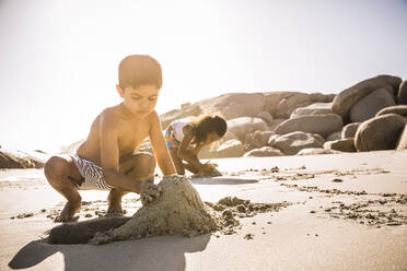 Junge baut gemeinsam eine Sandburg am Strand - SDAHF00470