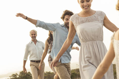 Eine große Familie genießt den Sonnenuntergang an der Strandpromenade, lizenzfreies Stockfoto