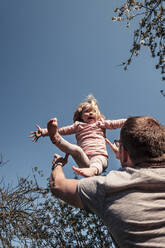 Father throwing little daughter in air - WFF00254