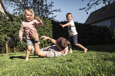 Father playing with his two kids in the garden - WFF00258