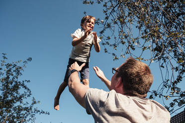 Father throwing little son up in air - WFF00260