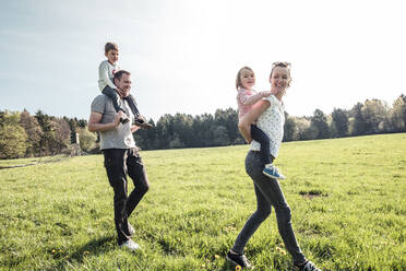 Glückliche Familie mit zwei Kindern auf einer Wiese im Frühling - WFF00277
