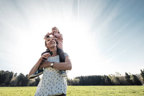 Mutter trägt kleine Tochter auf den Schultern im Frühling - WFF00280