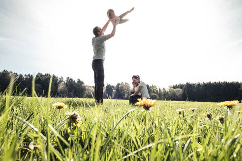 Glückliche Familie mit zwei Kindern auf einer Wiese im Frühling - WFF00283