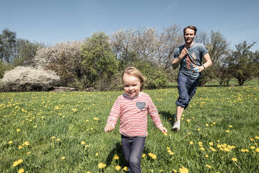 Kleines Mädchen und ihr Vater laufen auf einer Frühlingswiese - WFF00285