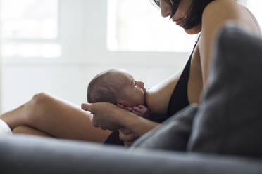 Mother breastfeeding newborn baby son - HOXF04917