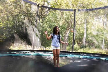 Girl jumping on trampoline - JOHF08800