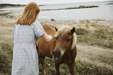 Girl with horse at seaside - JOHF08888