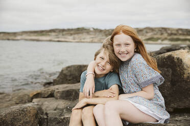 Brother and sister playing at seaside - JOHF08893