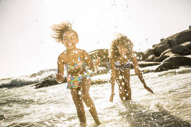 Happy mother and daughter splashing with water in the sea - SDAHF00497