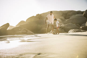 Vater und Sohn spielen Fußball am Strand - SDAHF00517