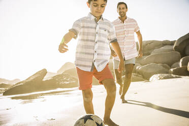 Vater und Sohn spielen Fußball am Strand - SDAHF00518