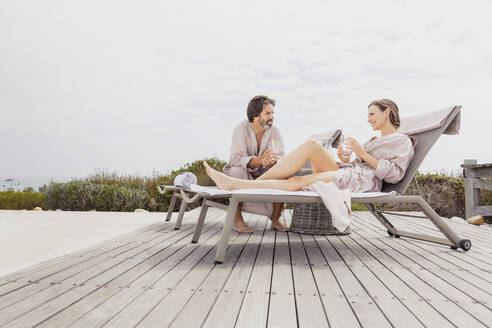 Couple relaxing on terrace at the poolside - SDAHF00536