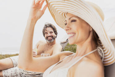 Happy couple relaxing on sun loungers - SDAHF00540