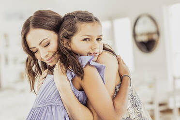 Affectionate mother hugging daughter at home - SDAHF00550