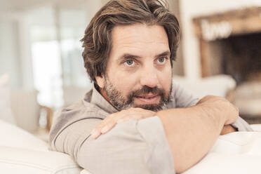 Portrait of bearded man sitting on couch - SDAHF00582