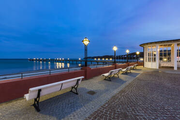 Deutschland, Mecklenburg-Vorpommern, Insel Rügen, Binz, Ostseebad, Kurhaus Binz, Kurplatz, Bänke an der Ostseepromenade in der Abenddämmerung - WDF05749