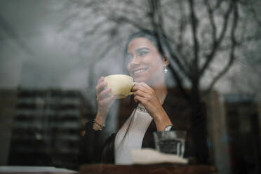 Glückliche junge Frau entspannt in einem Café - GRCF00159