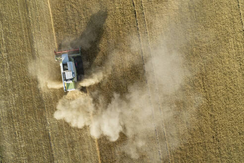 Deutschland, Bayern, Drohnenansicht eines Mähdreschers bei der Arbeit auf einem Feld - RUEF02627