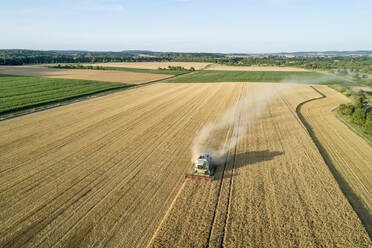 Germany, Bavaria, Drone view of combine harvester working in field - RUEF02630