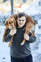 Teenage boy with dog on his shoulders - JOHF09030