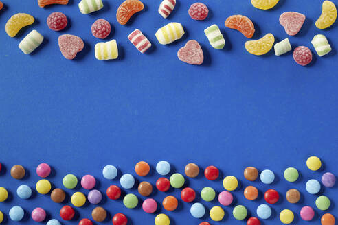 Colorful candies on bue background, copy space - DREF00052