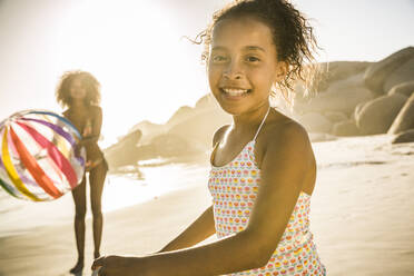 Portrait of happy girl playing with her mother on the beach - SDAHF00594