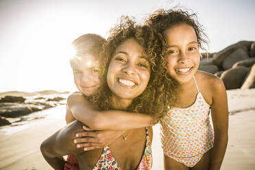 Portrait of a happy mother with her two kids having fun on the beach - SDAHF00603