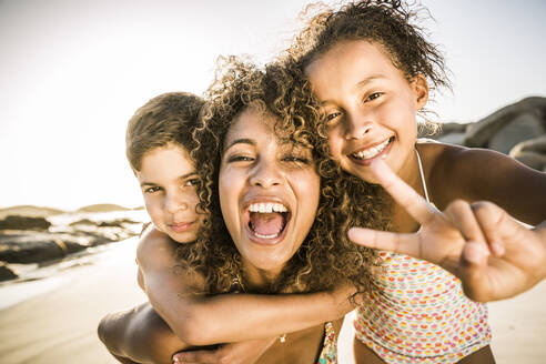Portrait of a happy mother with her two kids having fun on the beach - SDAHF00605