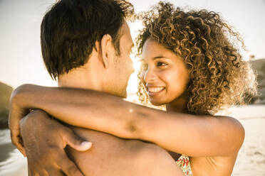 Happy couple hugging on the beach at sunset - SDAHF00615