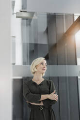 Porträt einer blonden Geschäftsfrau mit Blick in die Ferne - BMOF00170