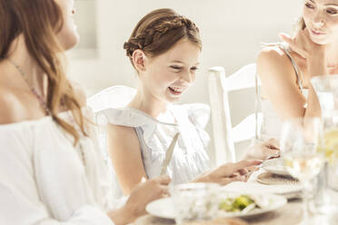 Glückliches Mädchen und zwei Frauen beim gemeinsamen Mittagessen - SDAHF00643