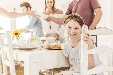 Porträt eines lächelnden Mädchens beim Mittagessen mit ihrer Familie, lizenzfreies Stockfoto
