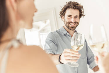 Portait of smiling man holding a glass of white wine - SDAHF00654