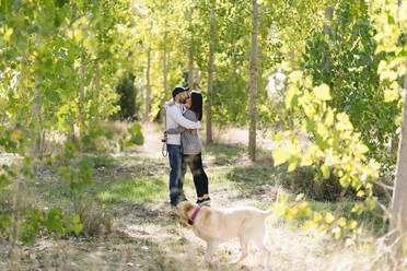 Ein Paar spielt mit seinem Hund in einem Park - DGOF00425