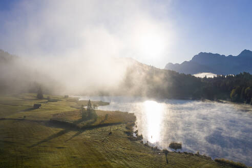 Deutschland, Bayern, Krun, Drohnenaufnahme von Nebelschwaden, die bei Sonnenaufgang über dem Geroldsee schweben - SIEF09539