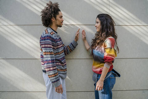 Couple of dancers face to face in front of a wall stock photo
