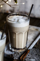 Glass of iced chai with frothy milk and cinnamon - SBDF04216