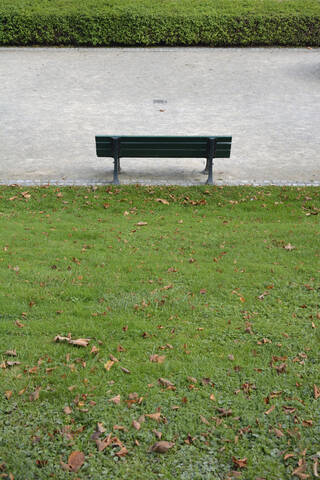 Deutschland, Bayern, München, Leere Parkbank vor einer Hecke stehend, lizenzfreies Stockfoto