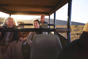 Glückliche Freunde fahren im Safari-Geländewagen - CAIF23749