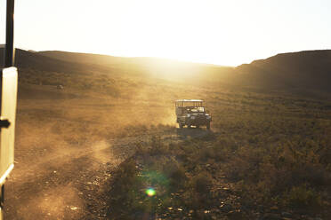 Safari off-road vehicle driving on sunny dirt road South Africa - CAIF23750
