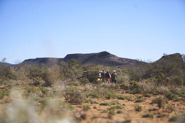 Safari-Tour-Gruppe zu Fuß zum Geländewagen im sonnigen Wildreservat - CAIF23769