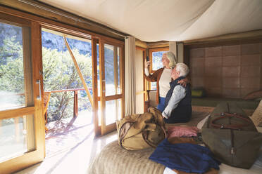 Älteres Paar benutzt Smartphone im Safari-Hotelzimmer - CAIF23781