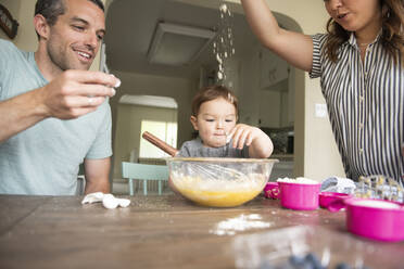 Glückliche junge Familie beim Backen - CAIF23796