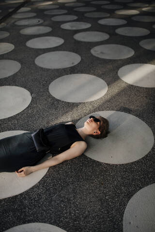 Elegant woman lying on ground with gray spots stock photo