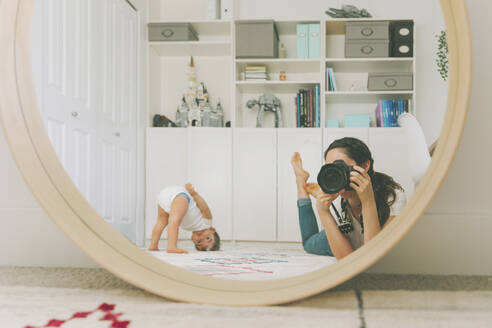 Spiegelbild einer Mutter, die sich und ihr Baby im Spiegel fotografiert - CMSF00084