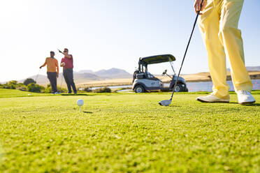 Golfer bereitet sich am sonnigen Abschlagplatz auf den Abschlag vor - CAIF23862