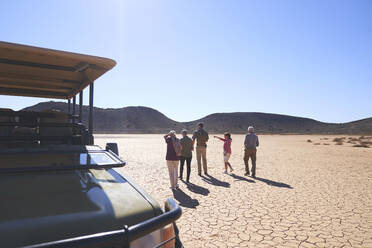 Safari-Gruppe mit Blick auf eine sonnige, trockene Landschaft in Südafrika - CAIF23917