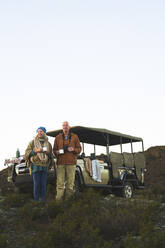Älteres Paar auf Safari trinkt Tee außerhalb des Geländewagens - CAIF23919
